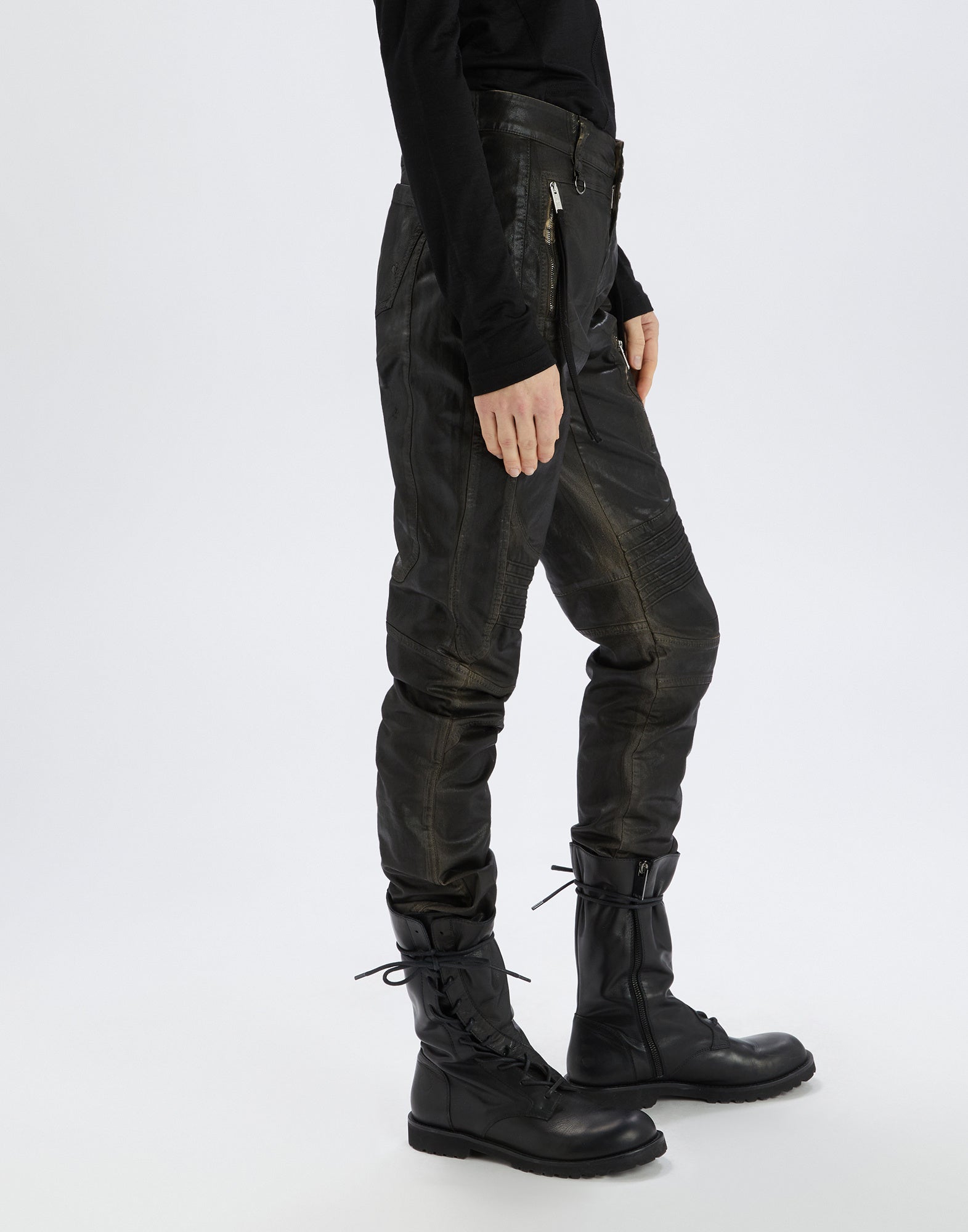 Side view of INKLING jeans with biker-inspired leather effect, visible zippers, knee topstitching, and slim fit, worn with black boots.
