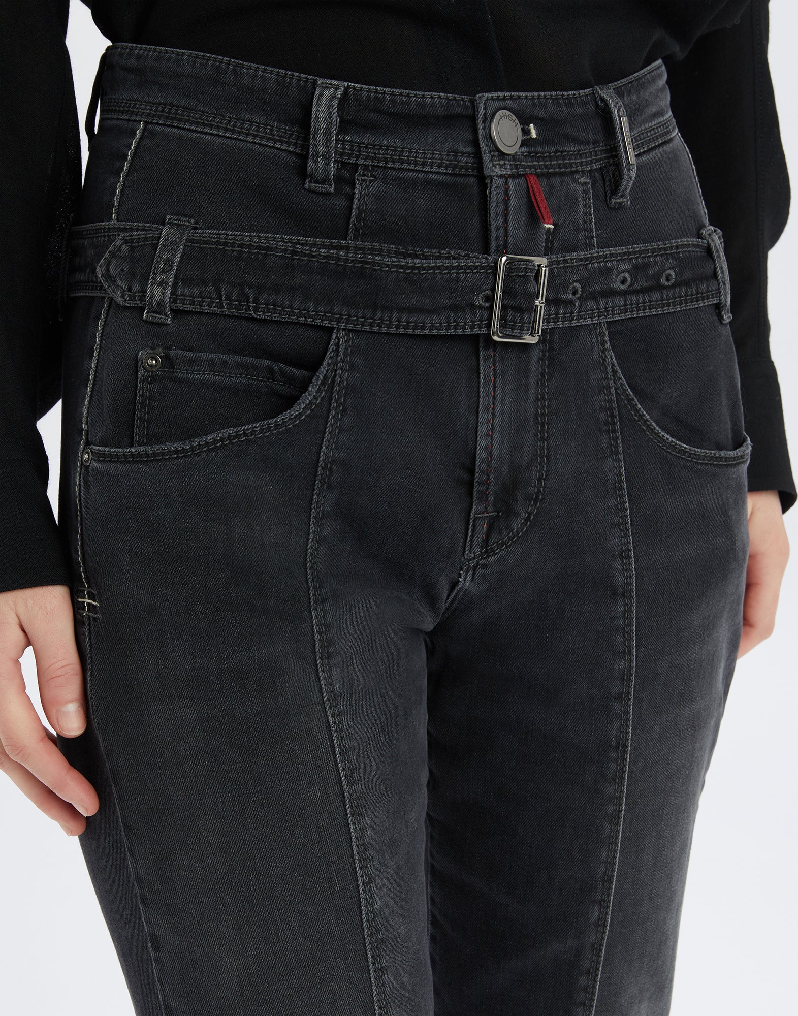 Front view of FAIR-PLAY: black jeans with removable double belt at hip height, visible seams, coin pocket, and front button.