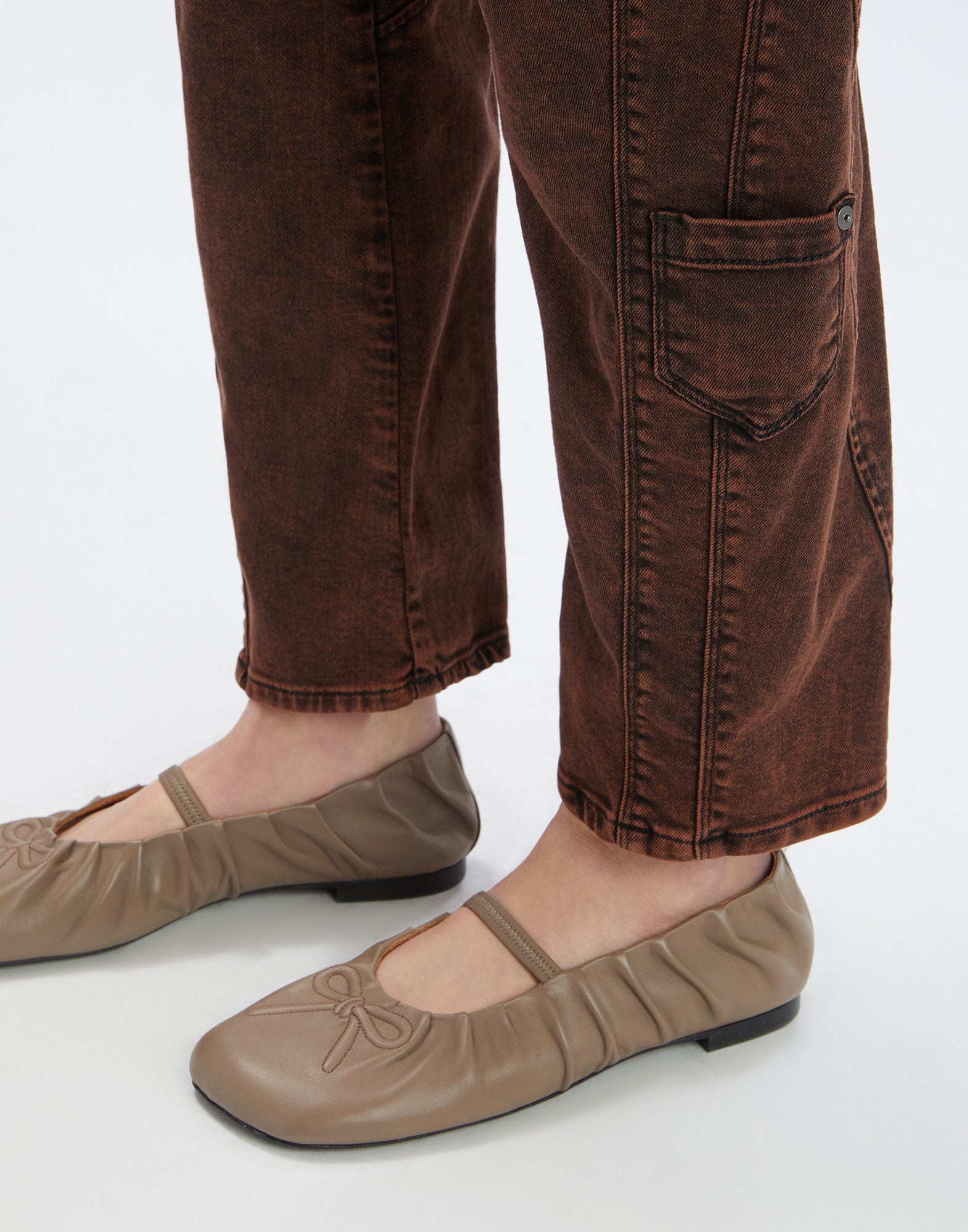 Detailansicht der WIDE LEG SADDLE Jeans von unten nach oben, zeigt den Used-Effekt des braunen Denims, sichtbare Nähte und eine schräge Oberschenkeltasche.