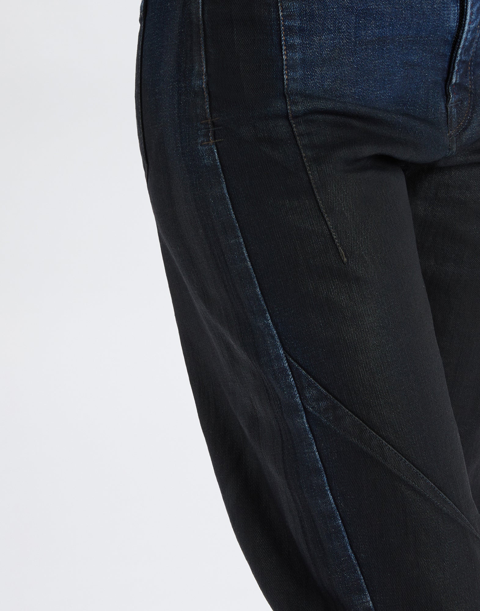 Detailansicht der TRICE Jeans, zeigt den mittleren Bereich mit leicht gebogener Beinform und markanter Naht, Denim mit Lederoptik-Finish.