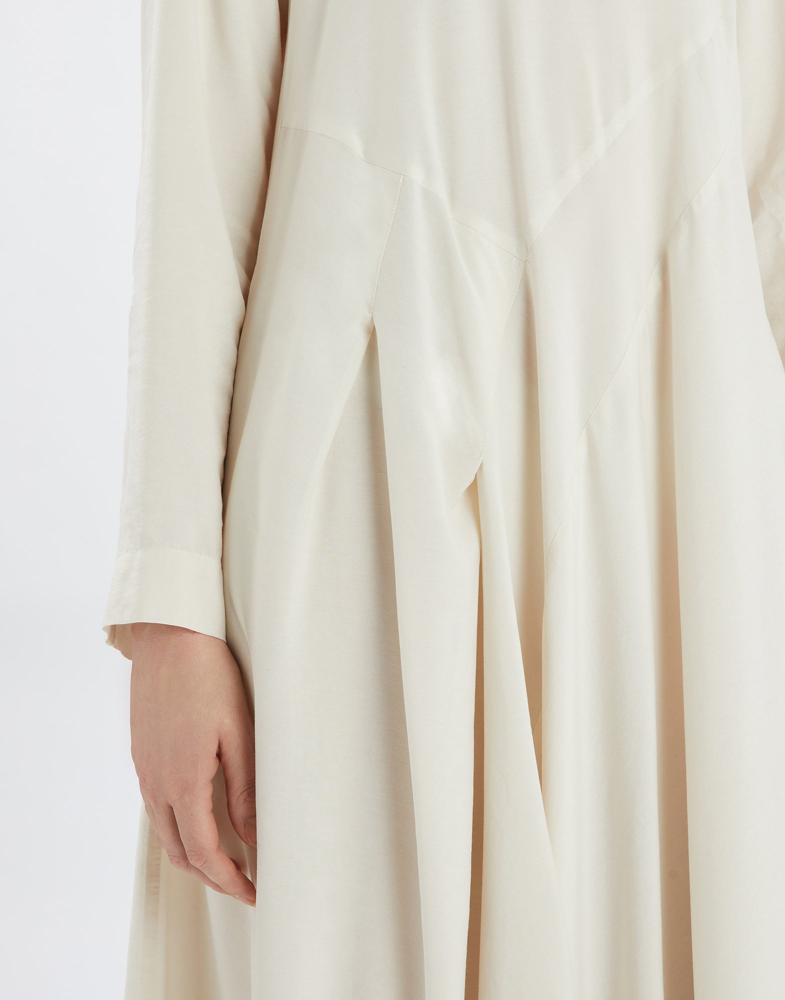 Side view detail of the AWAKENING dress in viscose and silk, showing long sleeves, fitted waist, and structured skirt seams.