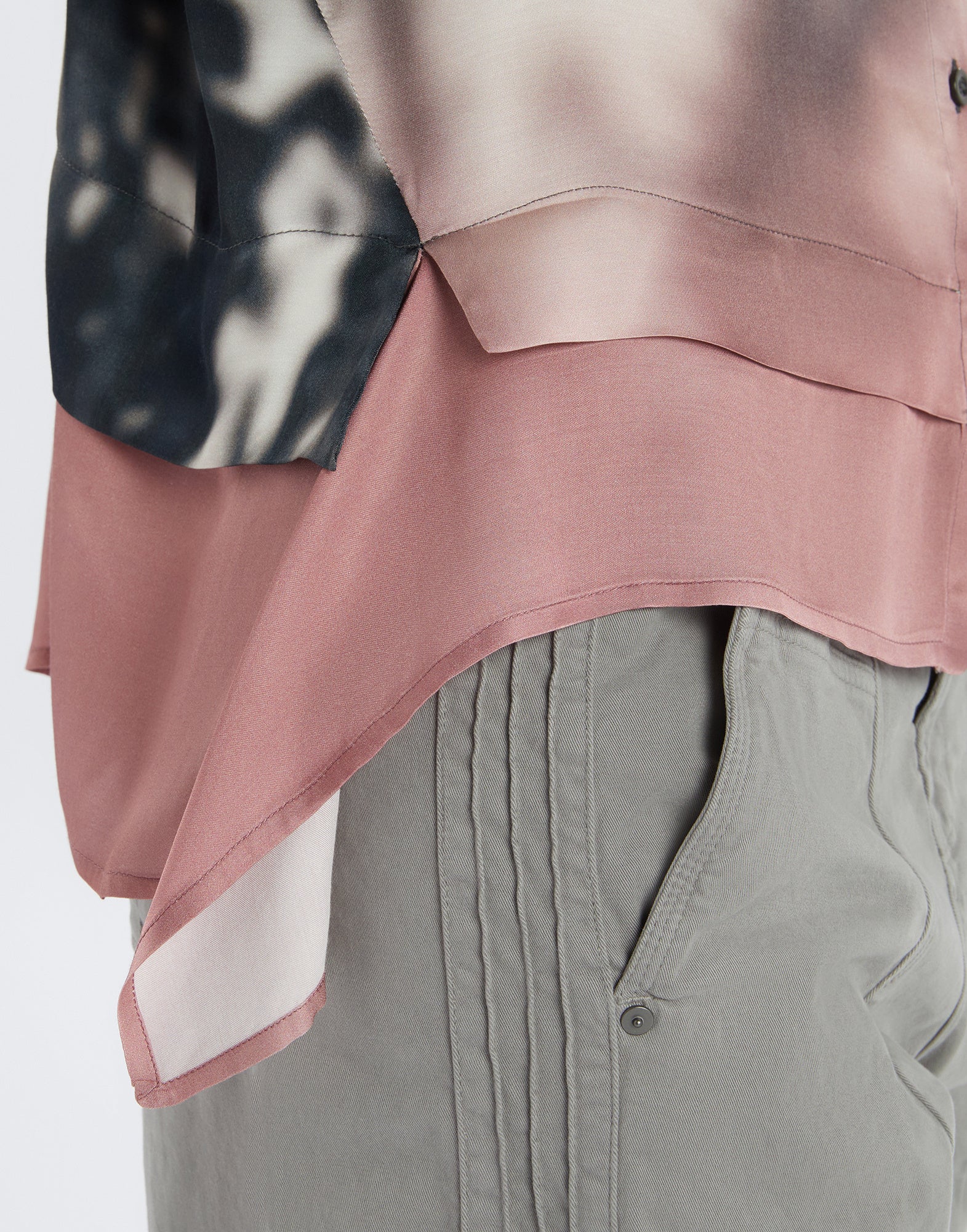Close-up view of the O-ZONE shirt, showcasing the transition from black and white to blush pink at the lower hem and the soft, flowing viscose fabric.