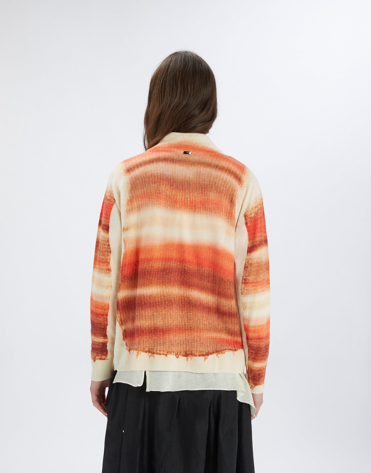 Rückansicht einer Person, die den RAMSEY Merinowollpullover mit Streifenprint in Orangetönen auf cremefarbenem Grund trägt, Stehkragen und Rippenbündchen sichtbar.