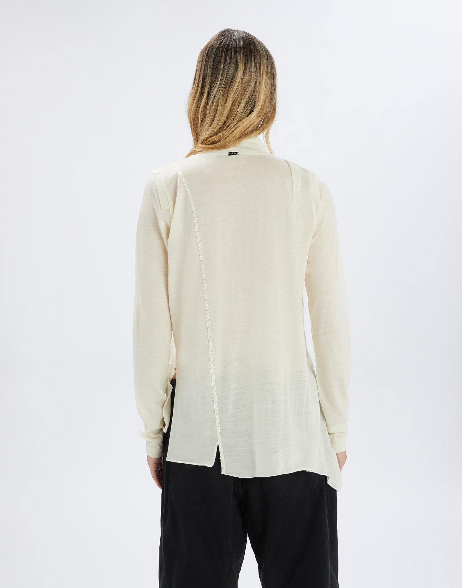 Rückansicht des Pullovers MATELOT mit langen Ärmeln, leichtem Woll-Jersey in hellem Ton, asymmetrischer Nahtführung und unregelmäßigem Saum, getragen von einer Person.