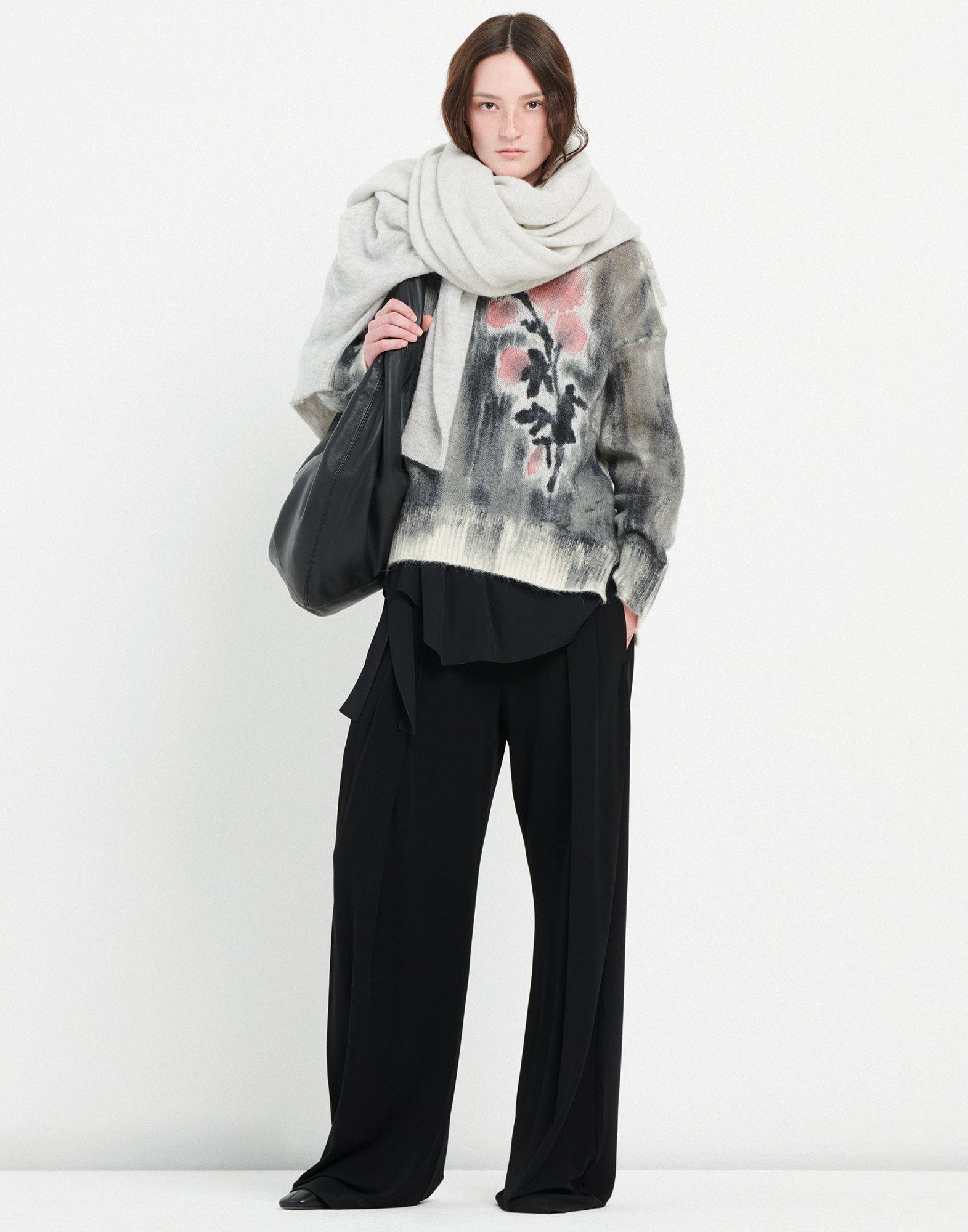 Front view: Person wearing SLIP-OVER pants made of fluid black viscose jersey with soft front pleats and wide, relaxed pajama style.