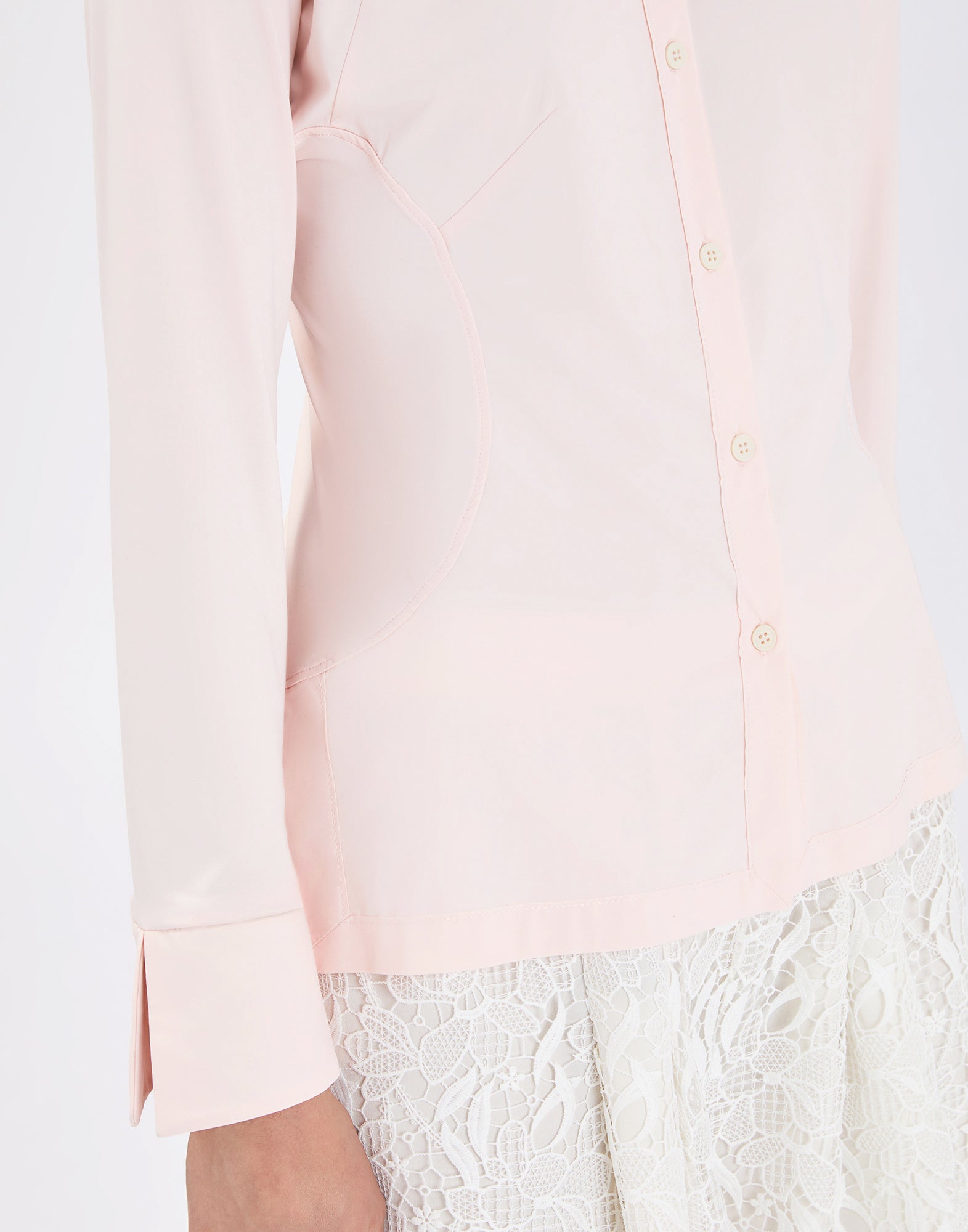 Detail view: INDEED shirt from the side, light pink, slim fit with visible darts, full front button placket and tall cuffs with slit, paired with a white lace skirt.