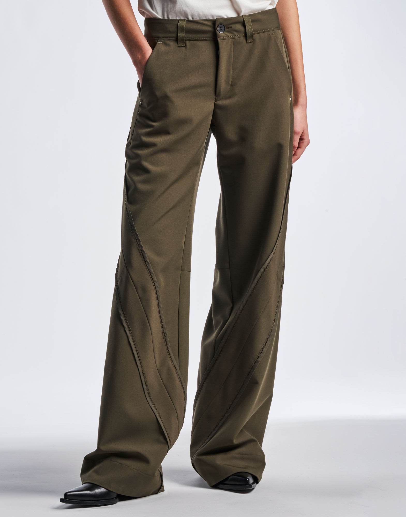 Front view: person wearing GRAVITATE wide leg pants in olive functional twill, waistband with button, belt loops, diagonal inserts and wide hem.