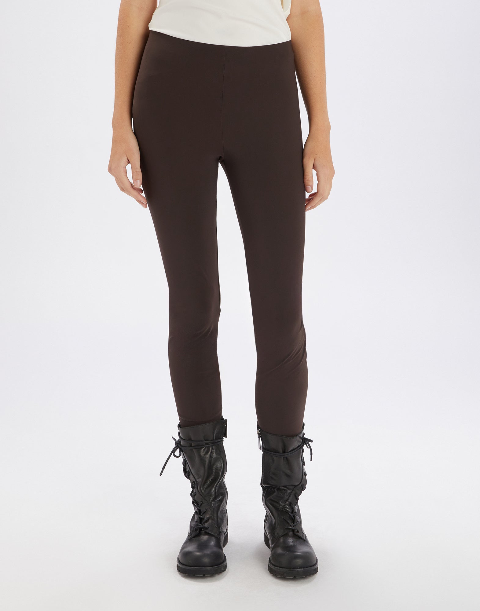 Front view of JEEPERS leggings in brown Sensitive(R) fabric, form-fitting, without seams or pockets, elastic waistband, high cuffs; paired with black boots.