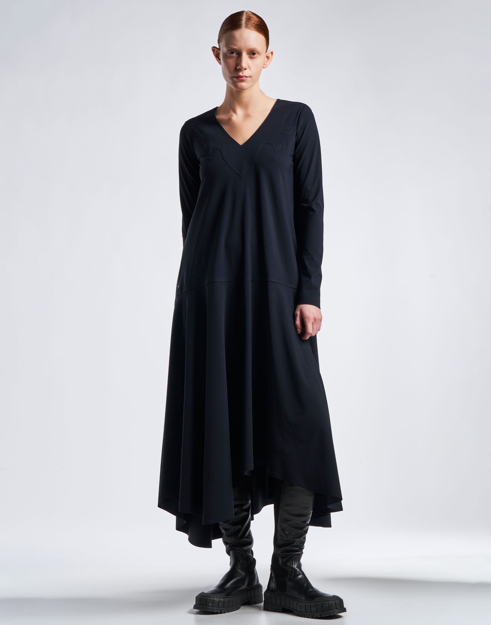 Front view: MAYBE dress in navy blue Sensitive(R) jersey, V-neckline, long sleeves, slight A-line silhouette. The skirt drapes longer at the back.