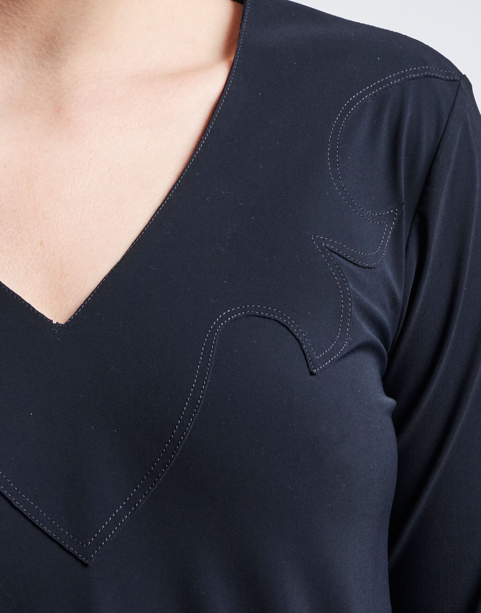 Detailansicht des MAYBE Kleids in navyblauem Sensitive-Jersey, zeigt V-Ausschnitt und Westernstil-Applikation am Oberkörper mit sichtbaren Nähten.