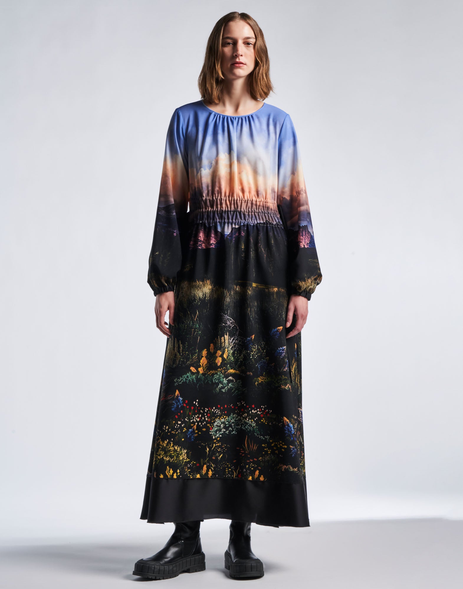 Front view: A woman wears the RHYMING maxi-dress in technical crepe de chine with multicoloured 'Wyoming' landscape print, elasticated bell sleeves, and floor-length skirt.