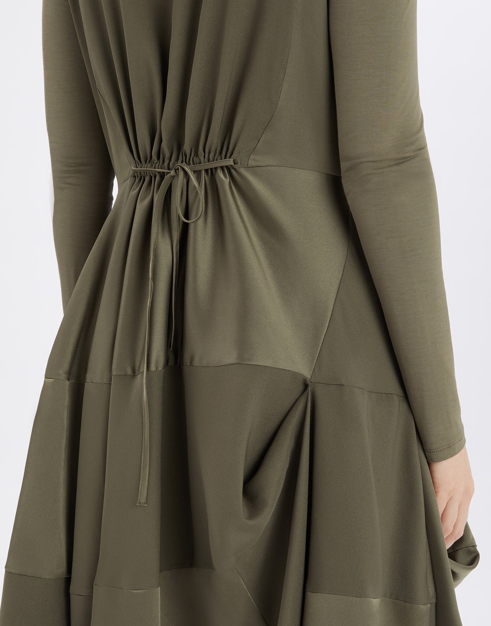 Back view of PLACID dress, olive green color, featuring waistband and visible draping in shiny polyester satin and jersey sleeves.