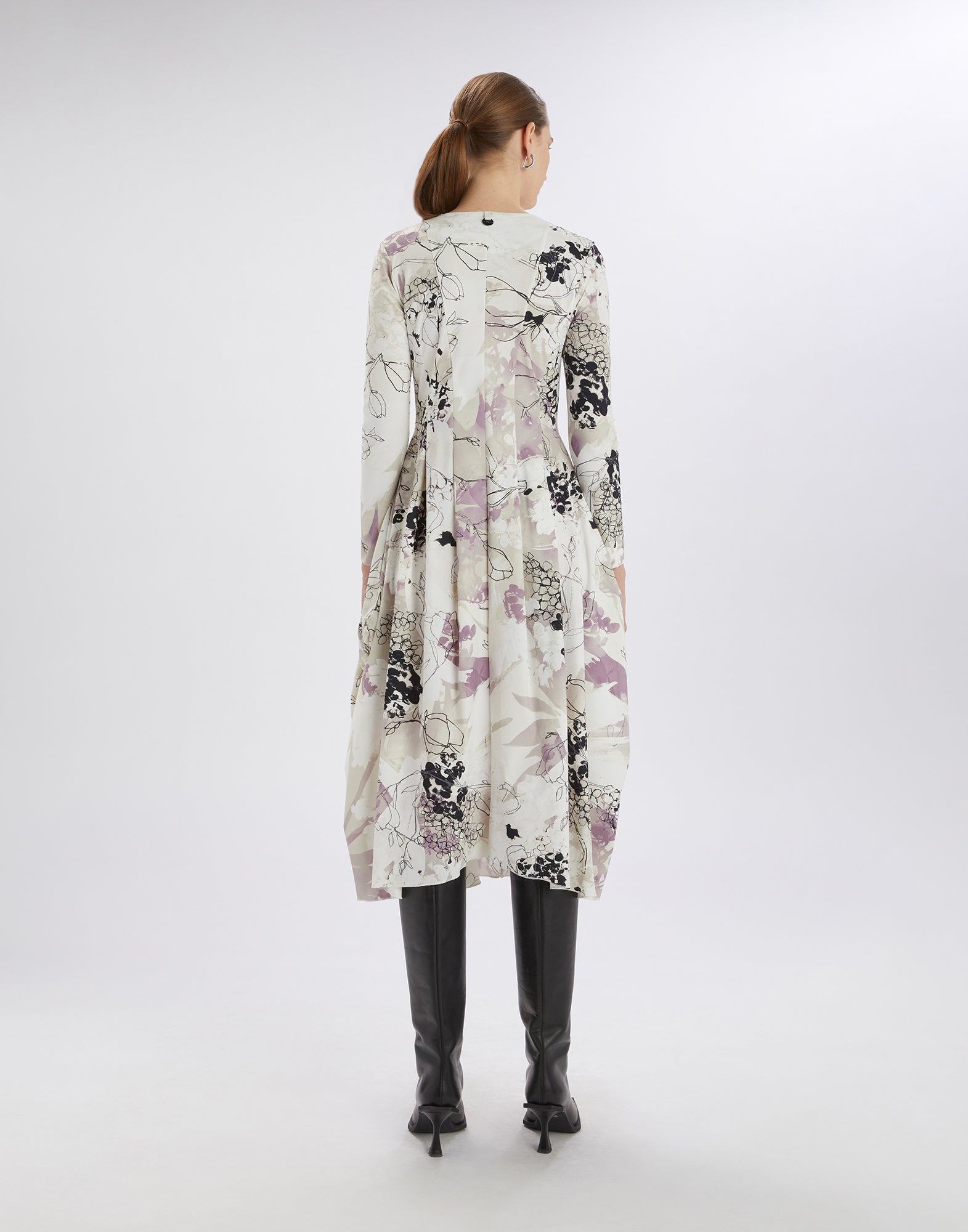 AT-LENGTH dress, rear detail view: balloon shape, long sleeves, floral Layered Flowers print in white, purple and black, mid-length cut, model standing upright.