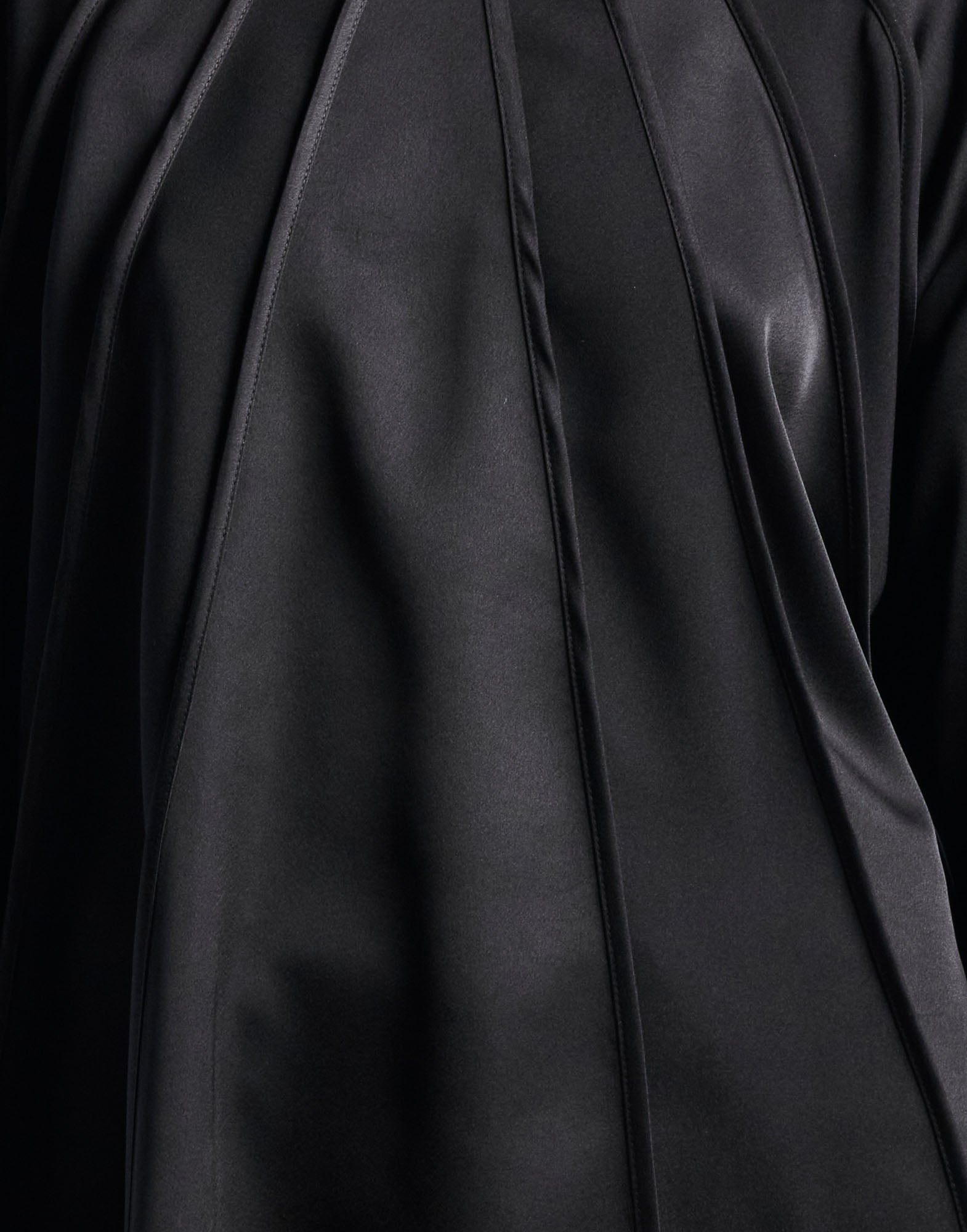Detailansicht des GIVE CHASE Oberteils aus abwechselnd mattem und glänzendem schwarzem Kreppsatin, die strahlenförmig vom Kragen verlaufen.