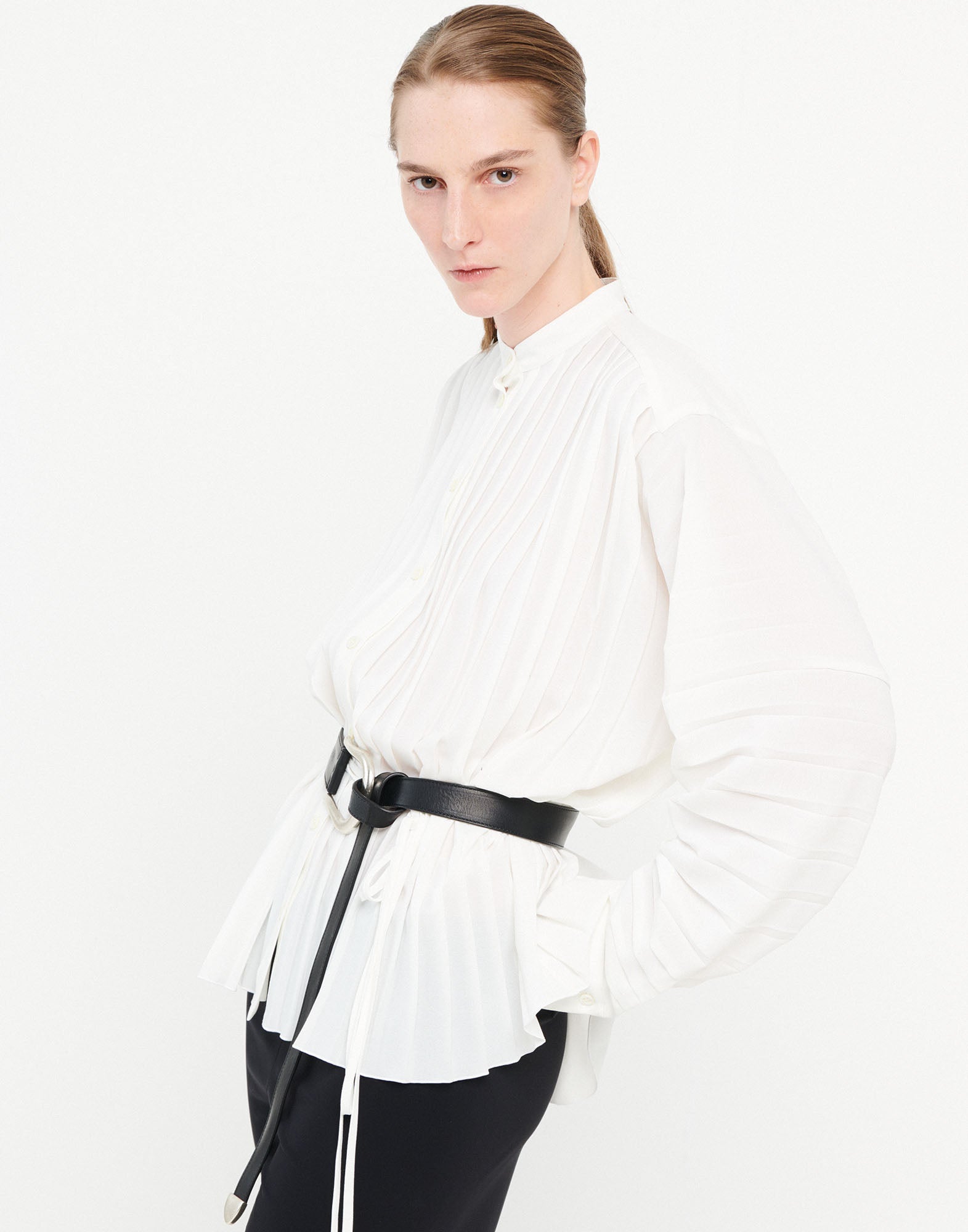 Front view: A person wears the white SLIM blouse with pleats, mandarin collar, and drawstring waist, paired with black trousers.