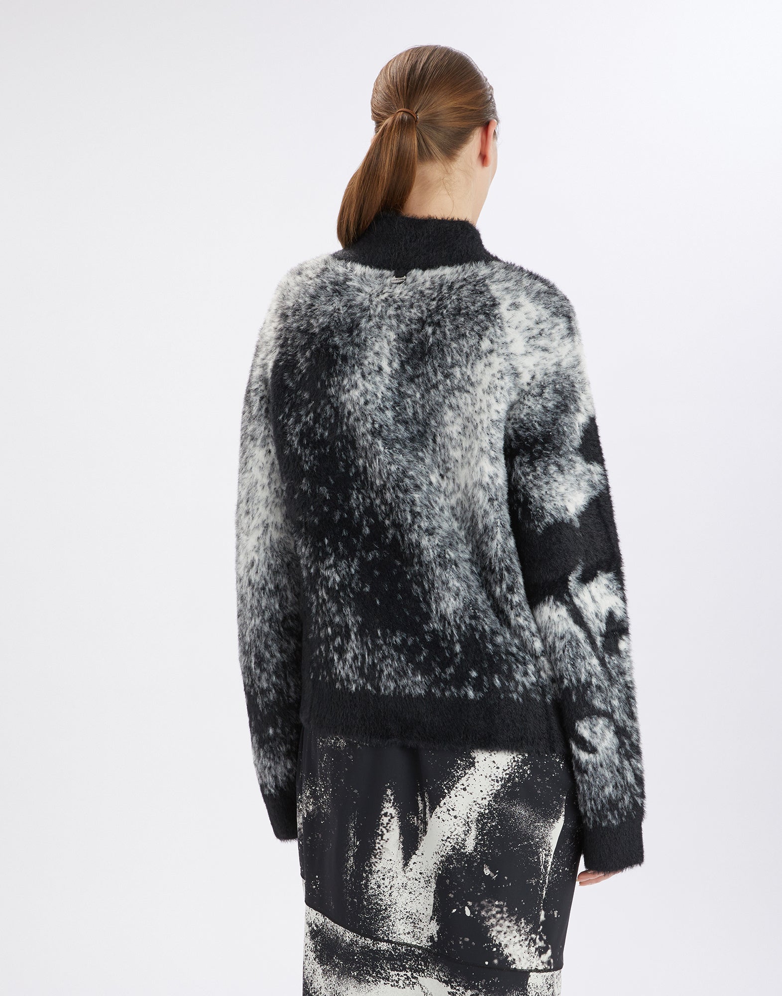 Rückansicht des Cardigans SUMMON UP, oversized in bicolor Jacquard, schwarz-weißes florales Muster am rechten Ärmel, Stehkragen, weicher Griff.