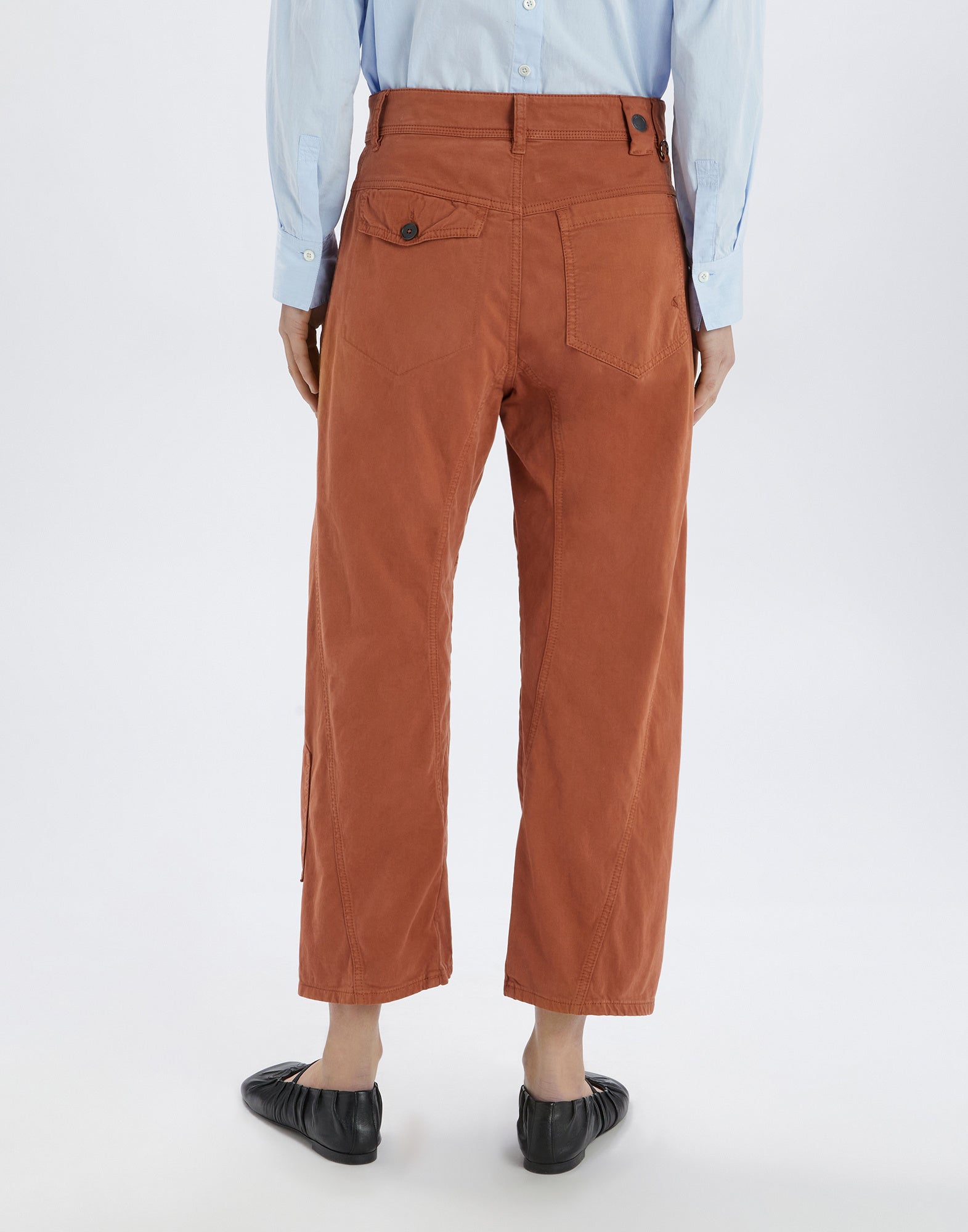 Rückansicht der Hose FURORE, in rostbrauner Farbe, mit aufgesetzter Tasche, Pattentasche mit Knopf und sichtbaren Nähten. Hose mit weitem Bootcut.