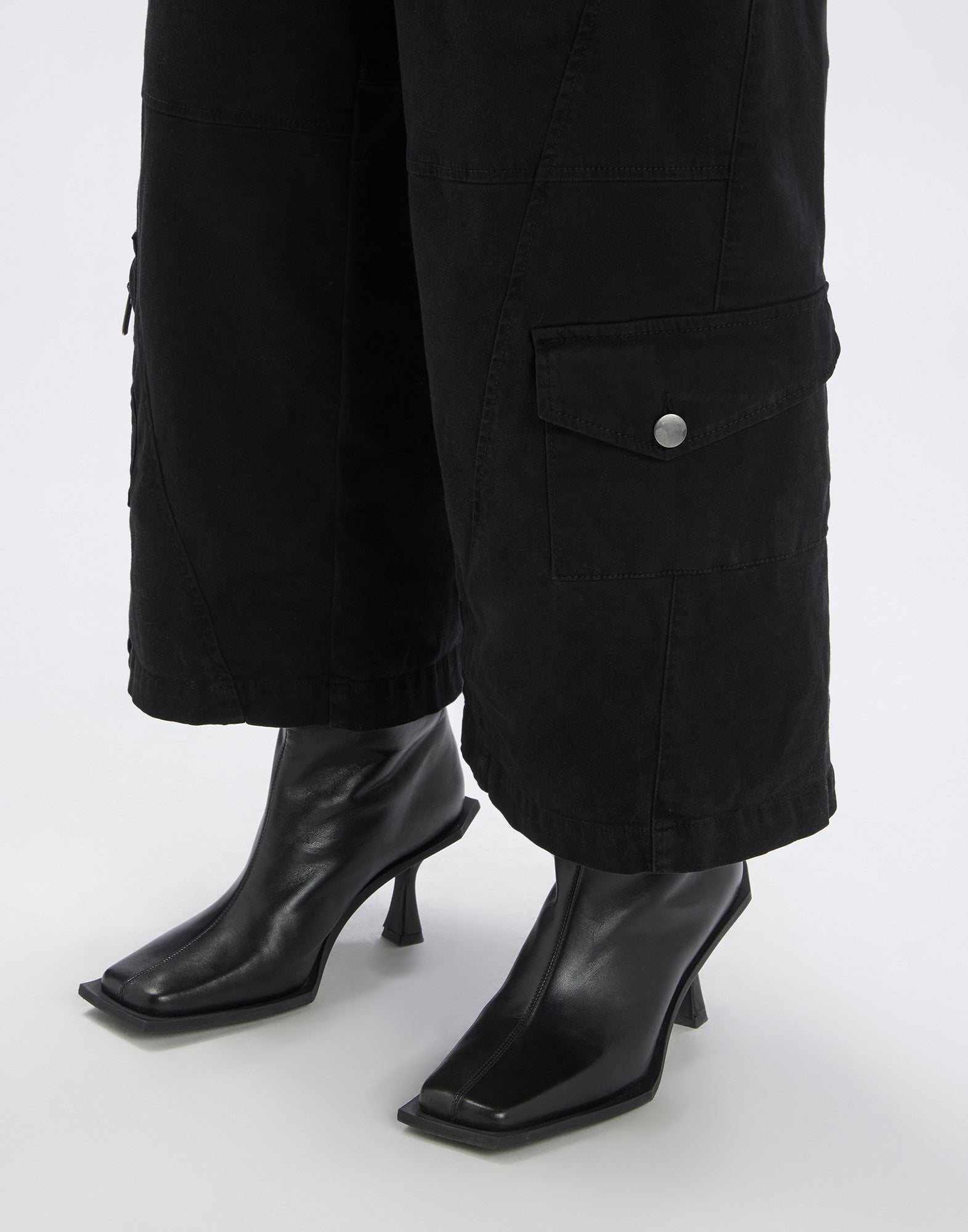 Front view shows OUT RUN trousers with wide leg, applied pockets, and visible topstitching, worn with black boots on a light background.