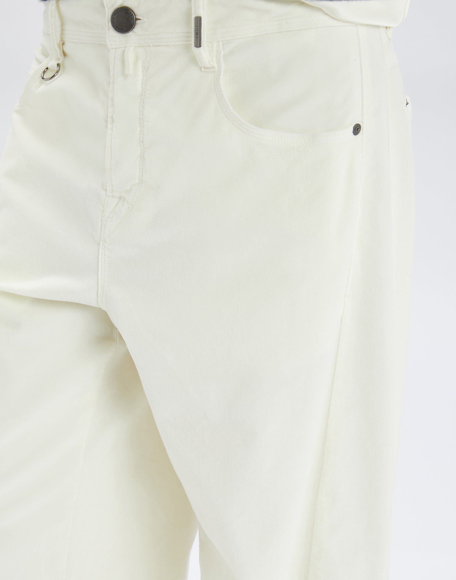 Detailansicht der GOTLAND Hose aus heller Baumwoll-Modal-Mischung, zeigt Bund mit Gürtelschlaufen, Frontknopf, Reißverschluss und vordere Tasche.