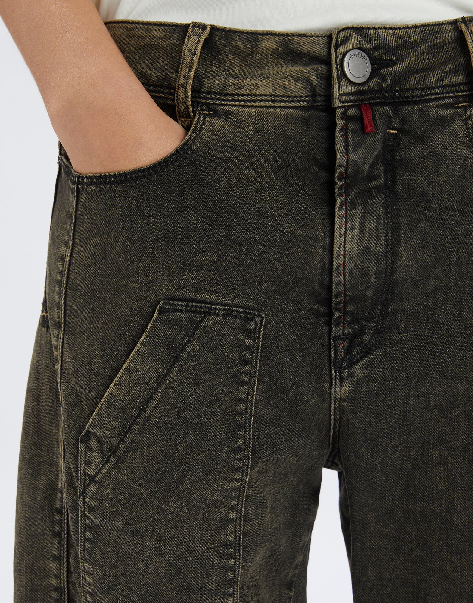 Detailansicht der WIDE LEG SADDLE Jeans von vorne, zeigt Used-Effekt, Gürtelschlaufe, Knopfverschluss, sichtbare Nähte und schräge Tasche am Oberschenkel.