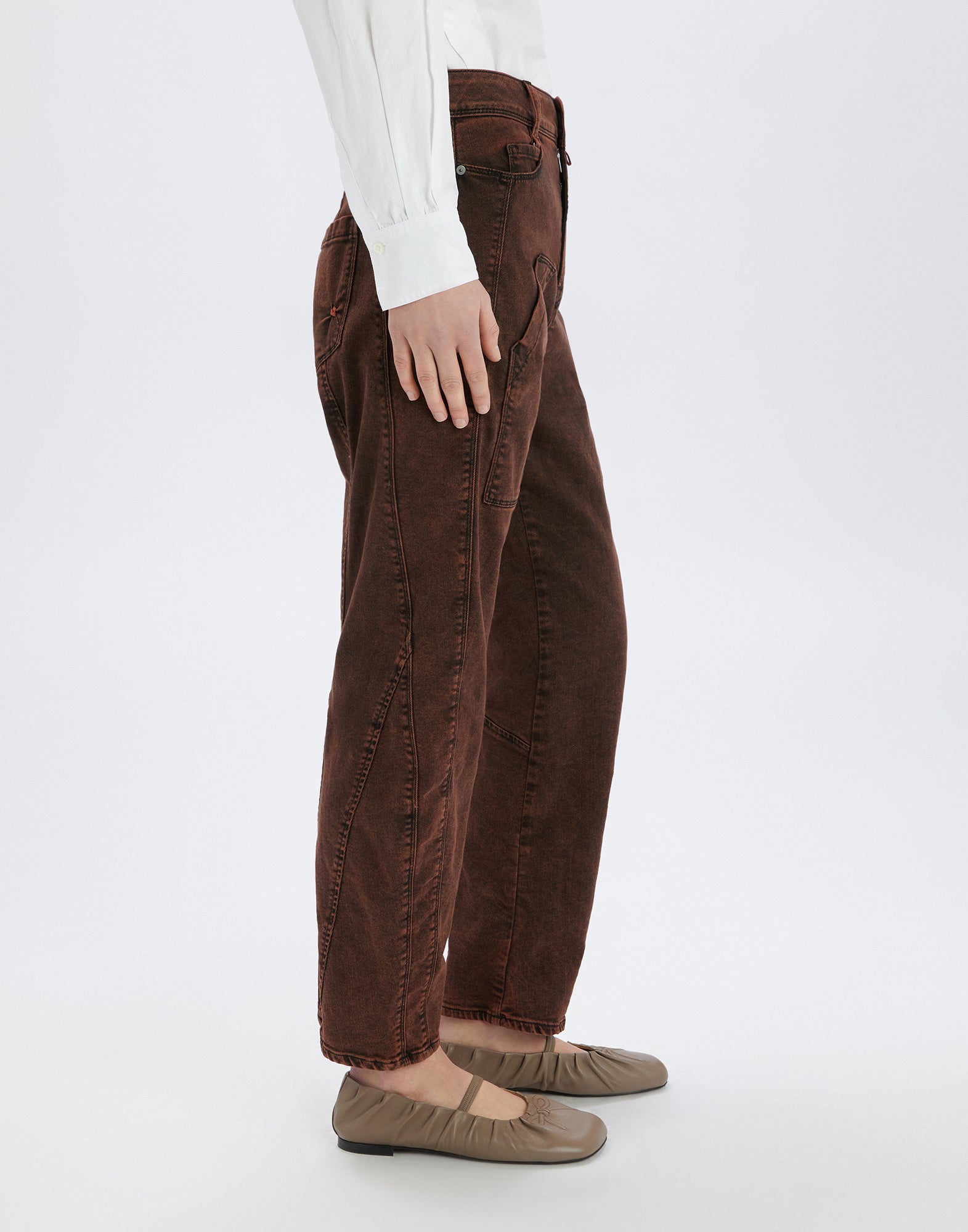 Side view of a person wearing the WIDE LEG SADDLE jeans in brown vintage look, showing wide leg, visible topstitching, and side pockets.