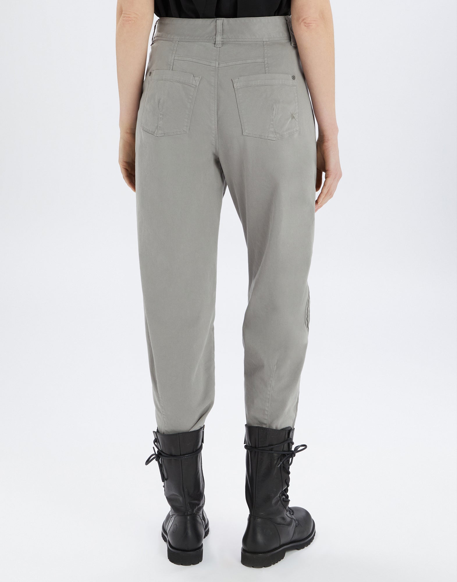 Rückansicht einer Person, die die graue Hose ACTIVATE trägt. Sichtbar sind zwei aufgesetzte Gesäßtaschen, Gürtelschlaufen und sichtbare Nähte. Die Hose endet oberhalb schwarzer Stiefel.