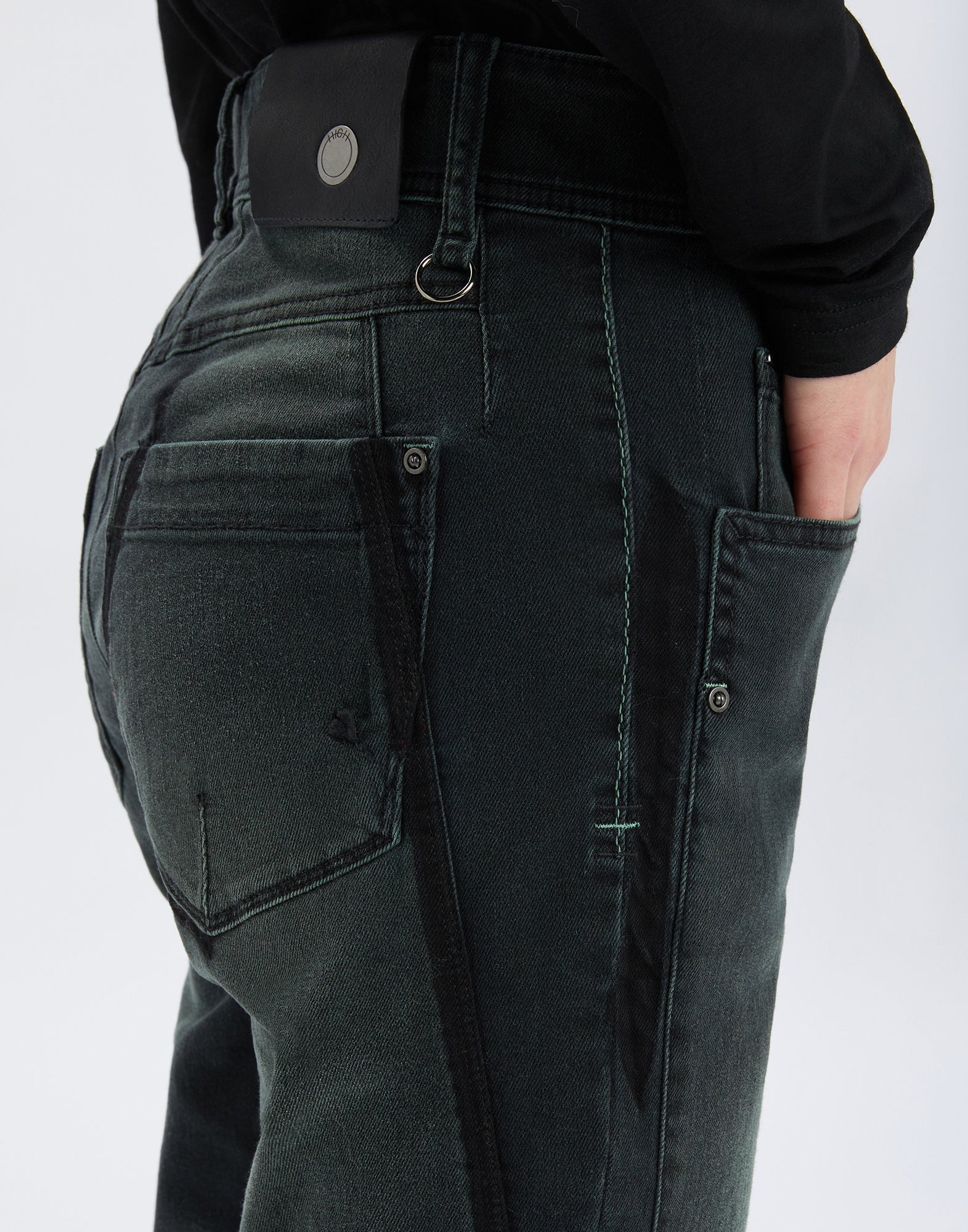 Detailansicht, Rückseite einer HAPPLY Jeans mit dunkleren Einsätzen, sichtbaren Nähten, aufgesetzter Gesäßtasche und Lederetikett am Bund.