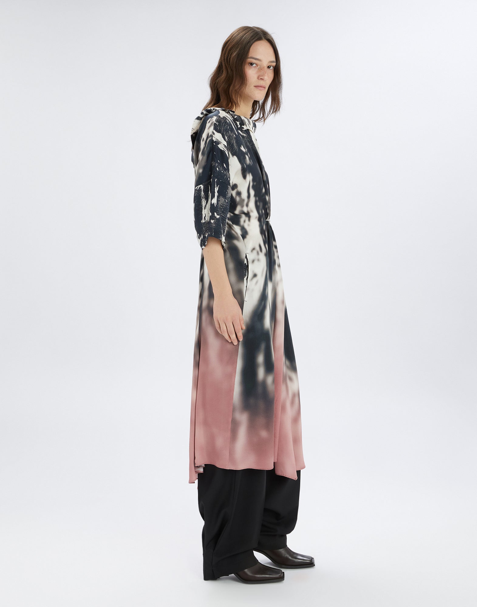 Seitenansicht: STOP PRESS Kleid mit abstraktem Schwarz-Weiß-Druck, Verlauf zu Rose-Pink, D-Ring-Detail vorn, asymmetrischem Saum und Dreiviertel-Ärmeln.