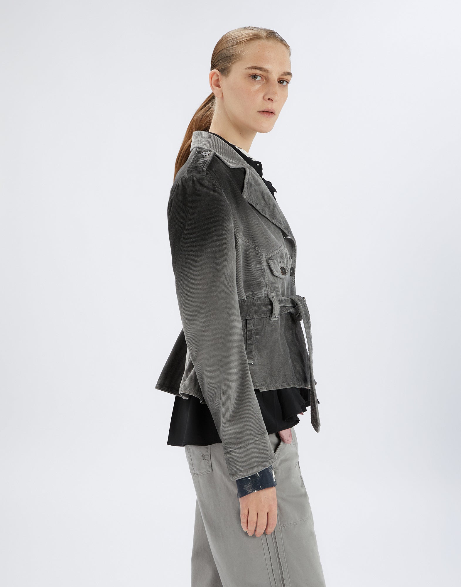 Seitenansicht der GIG Bikerjacke aus grauem Cordstoff, mit breiten Revers, Taillengürtel, Knopfleiste, Brusttasche mit Patte und sichtbaren Nähten.