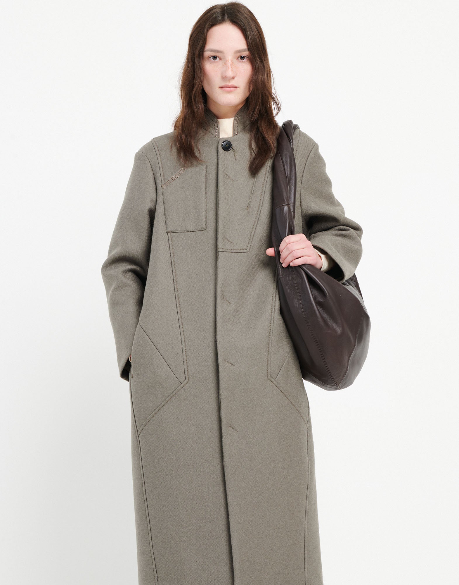 Front view: person wears the PANTO coat in oversized fit with stand collar, visible button, and seam detailing. Side pockets and chest pocket visible.