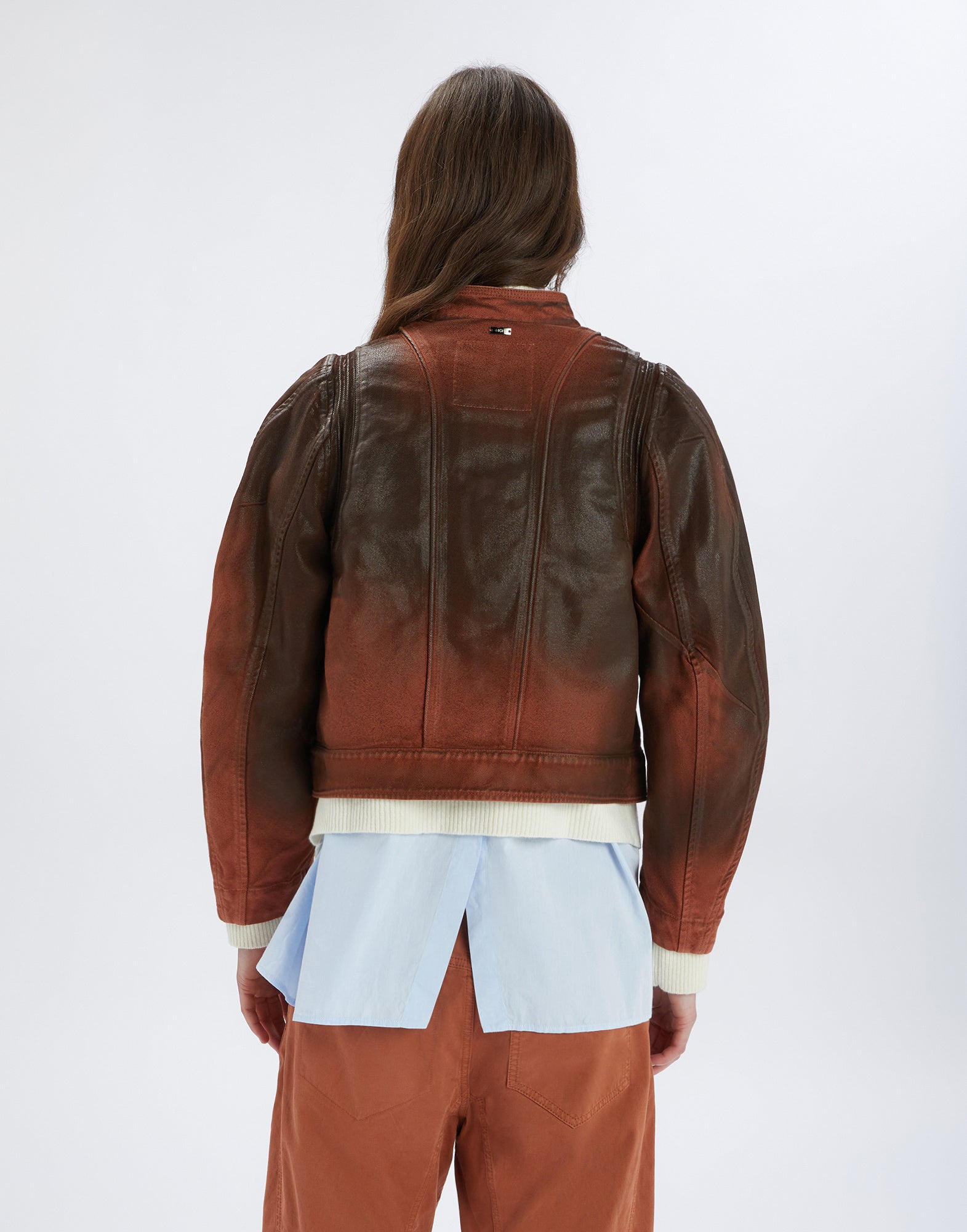 Rückansicht der TENDRIL Jacke, getragen von einer Person. Die Jacke aus Denim im Lederlook zeigt sichtbare Steppnähte und einen Boxy-Schnitt.