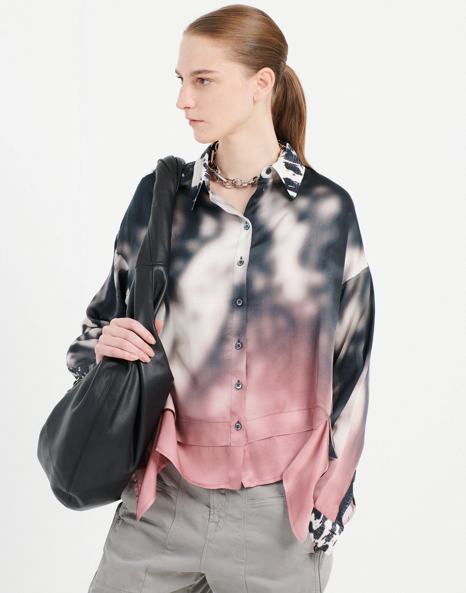 Front view of a person wearing the O-ZONE shirt. The shirt features a gradient from white-black to powder pink, turn-down collar, long sleeves, and visible button placket.