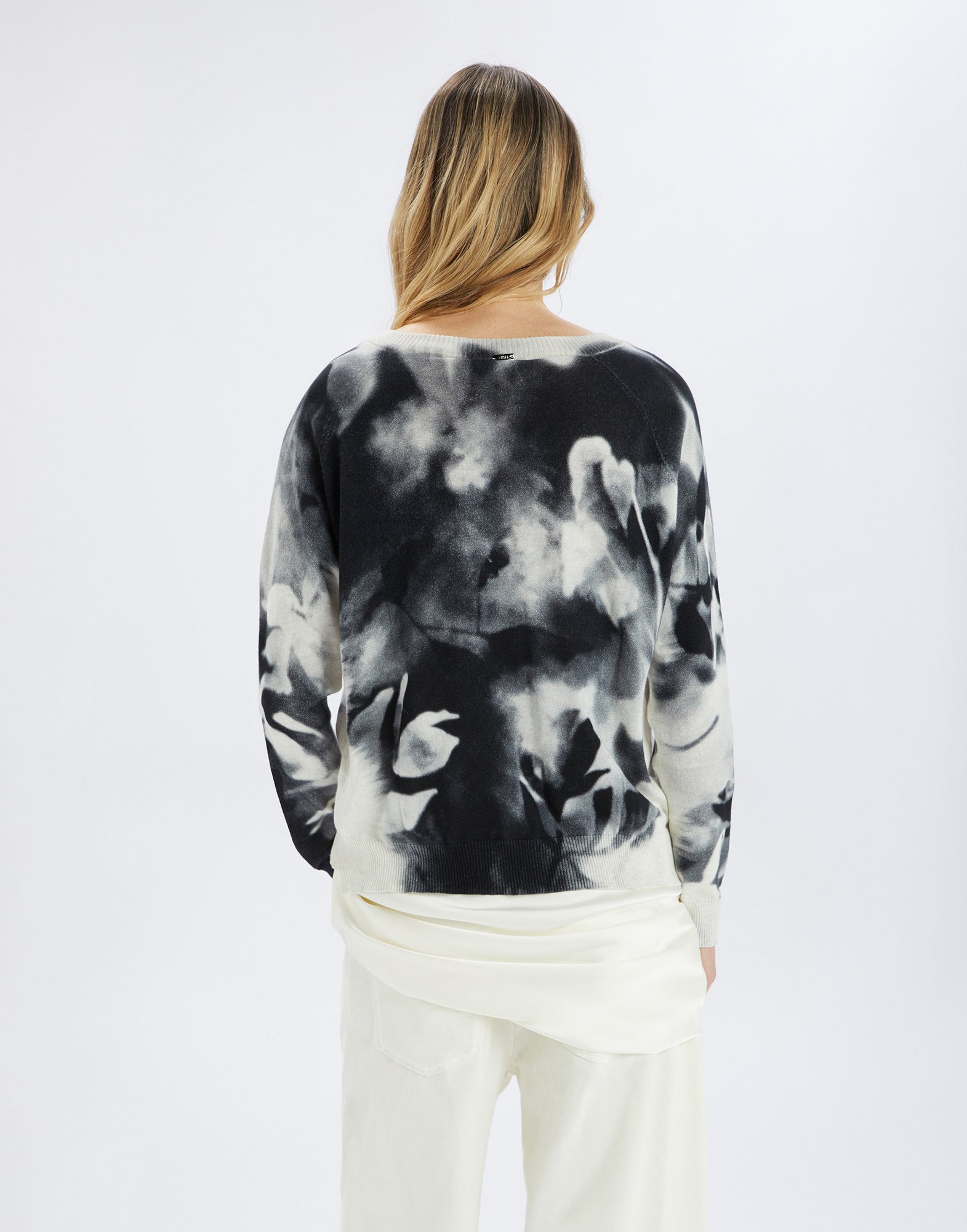 Back view shows the CECILIA sweater with floral, shaded print pattern in white and black, relaxed fit, and slightly dropped shoulders.