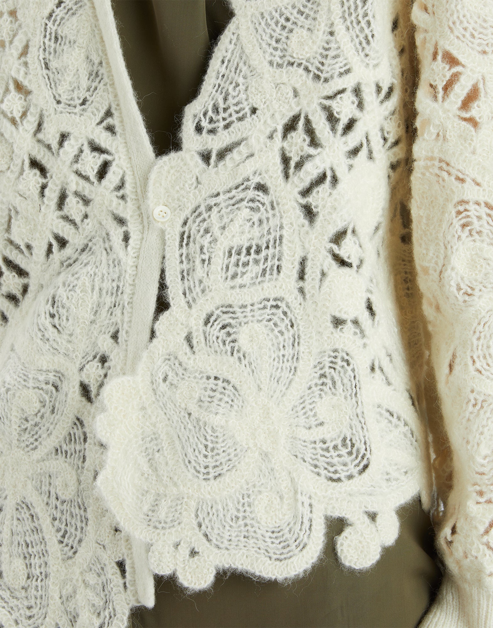 Detail view of the BOHEME cardigan featuring delicate openwork floral embroidery in cream white, medium weight, soft handfeel, visible button fastening.