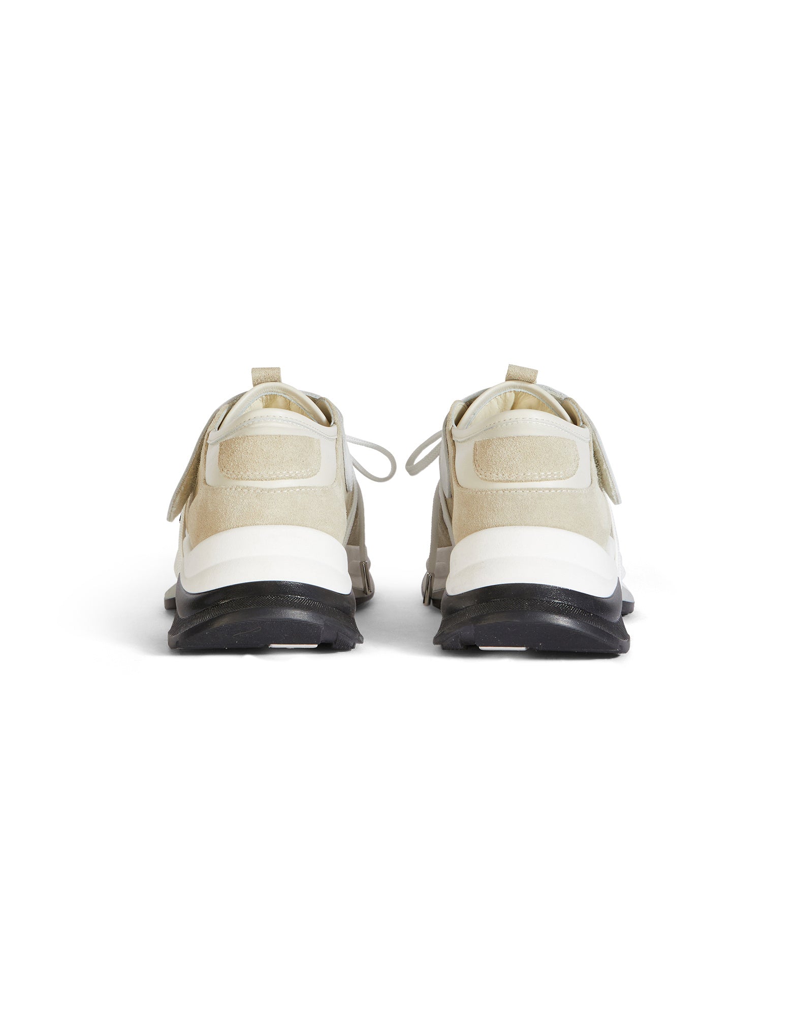 Rückansicht der PARTIAL Sneaker mit tonalen Ledersorten, heller Farbe, gepolsterter Colorblock-Sohle und Klettband über der Ferse. Partiell sichtbare Schnürsenkel.