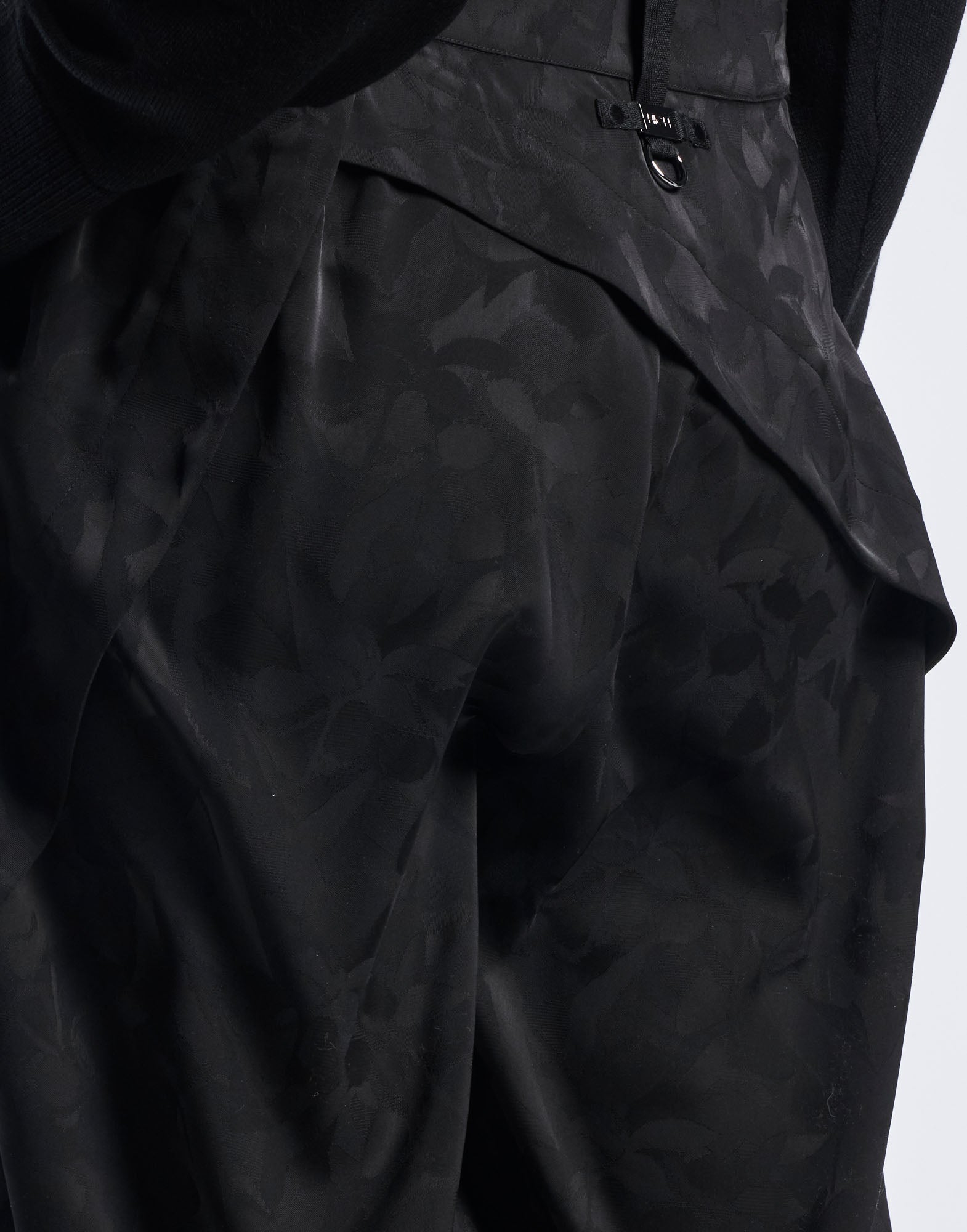 Detailansicht, seitlicher Blick auf BORDERLINE Hose aus Funktionssatin mit Damast-Blumenmuster. Sichtbar sind Bund, Metallverschluss und strukturierte Nahtdetails.