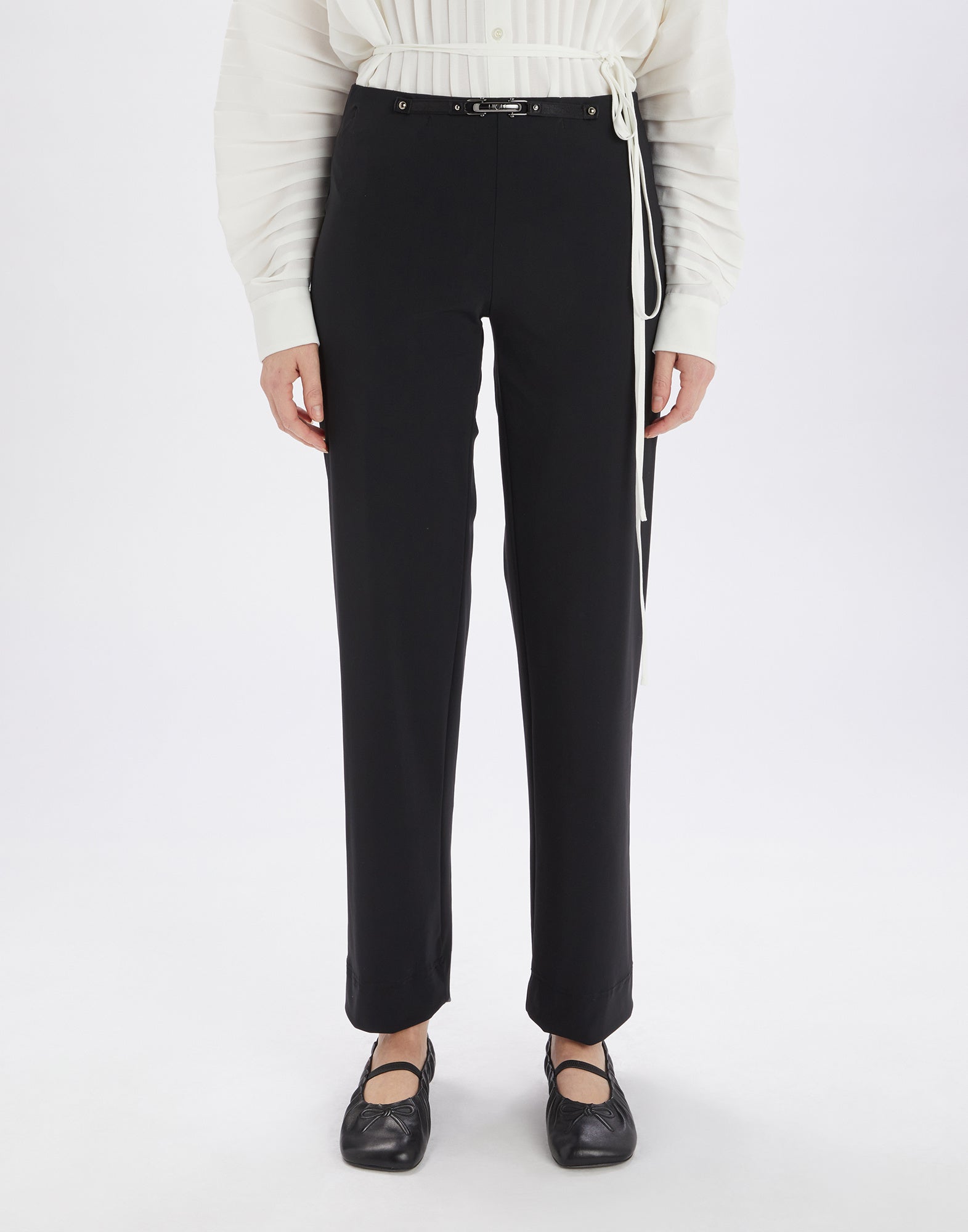 Frontalansicht: Die PROCEED Hose umhüllt die Beine in Schwarz, ohne Taschen und sichtbare Nähte, mit elastischem Bund, Leder- und Metallelementen vorn.