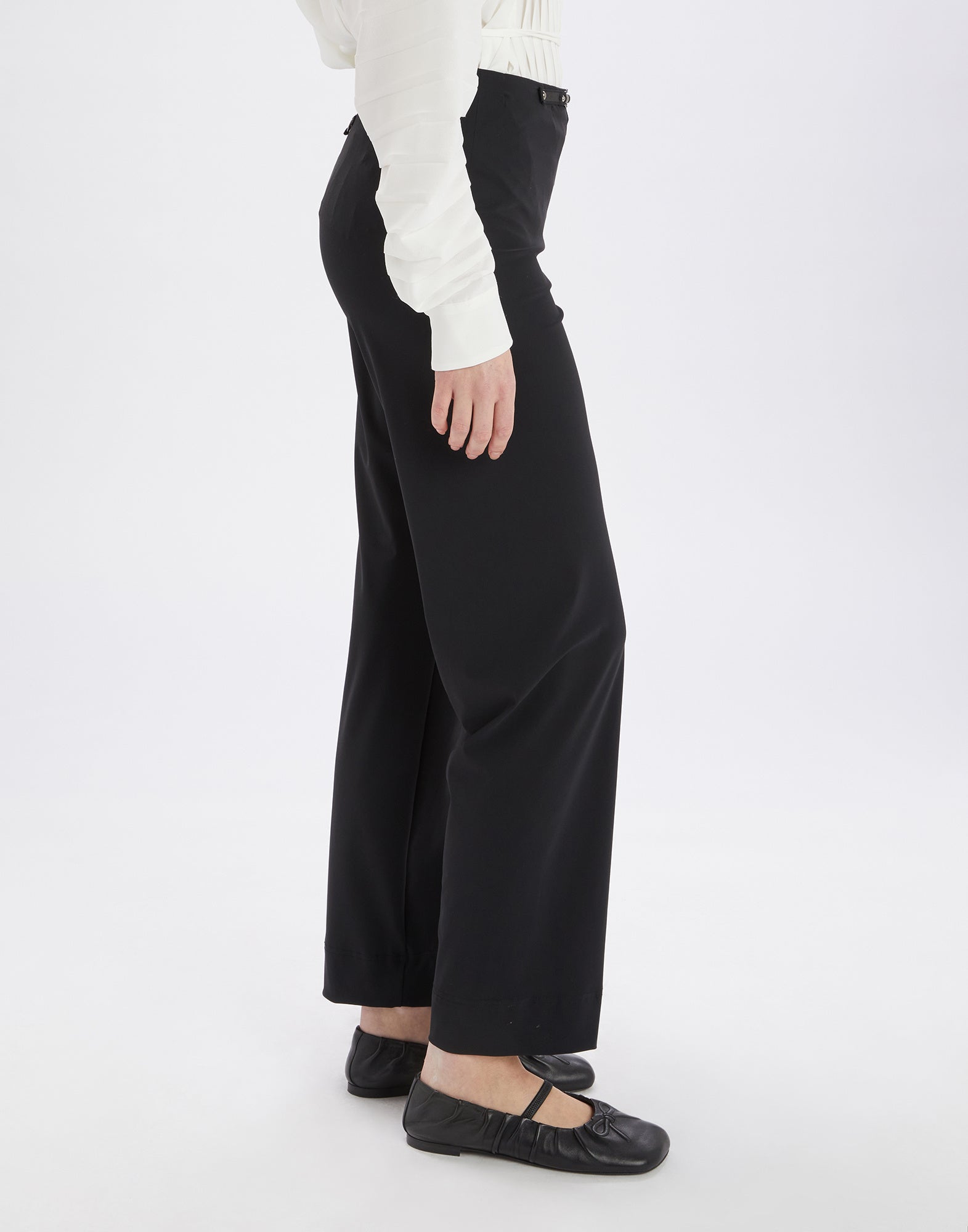 Side view of the black PROCEED pants worn by a person. The pants feature wide legs, no visible hem, and an elastic waistband.