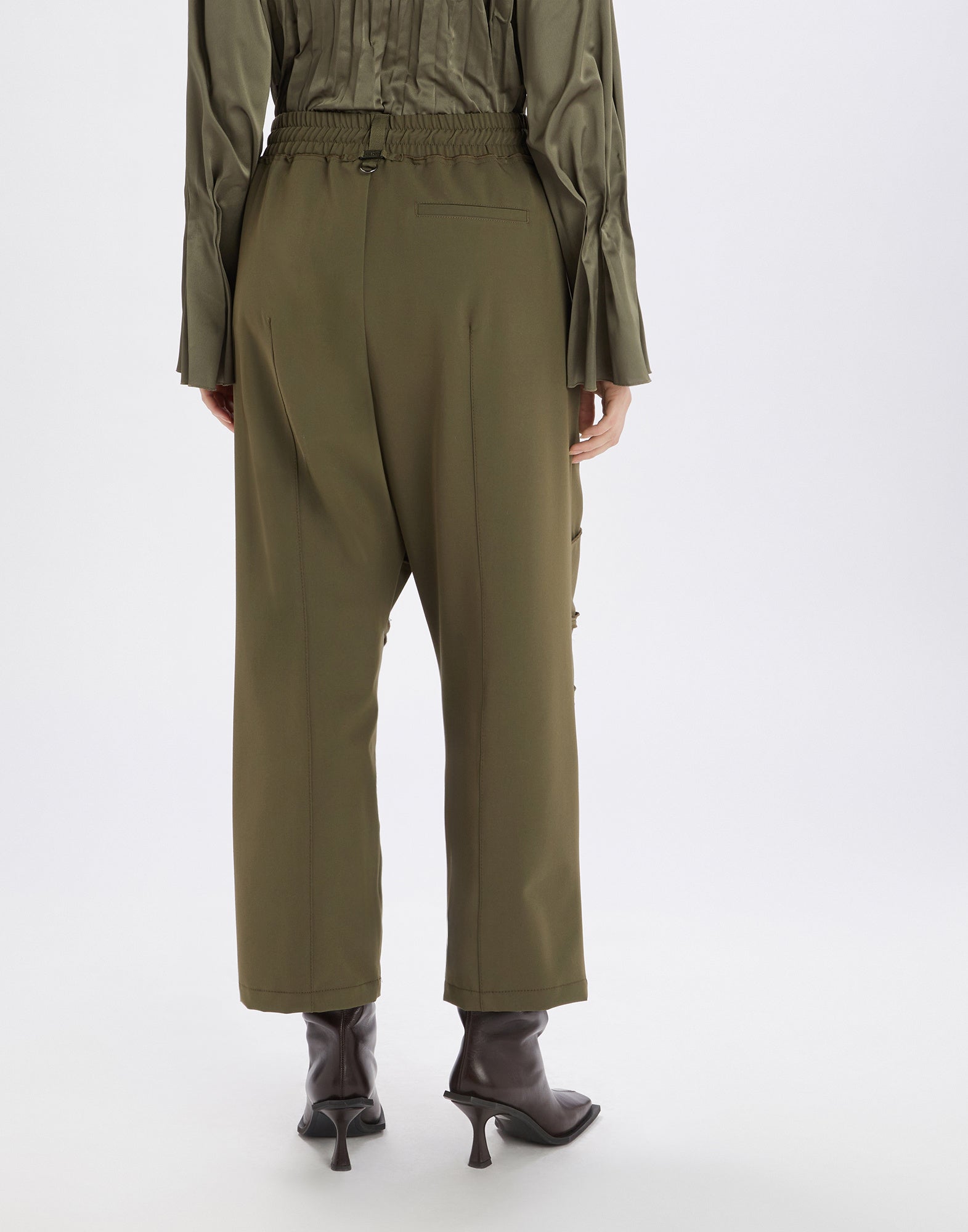 Rückansicht der SHEILA Hose in Olivgrün, mit elastischem Bund, Kordelzug und dekorativer mittlerer Steppnaht. Kombination aus sportlichem Charakter und eleganten Details.