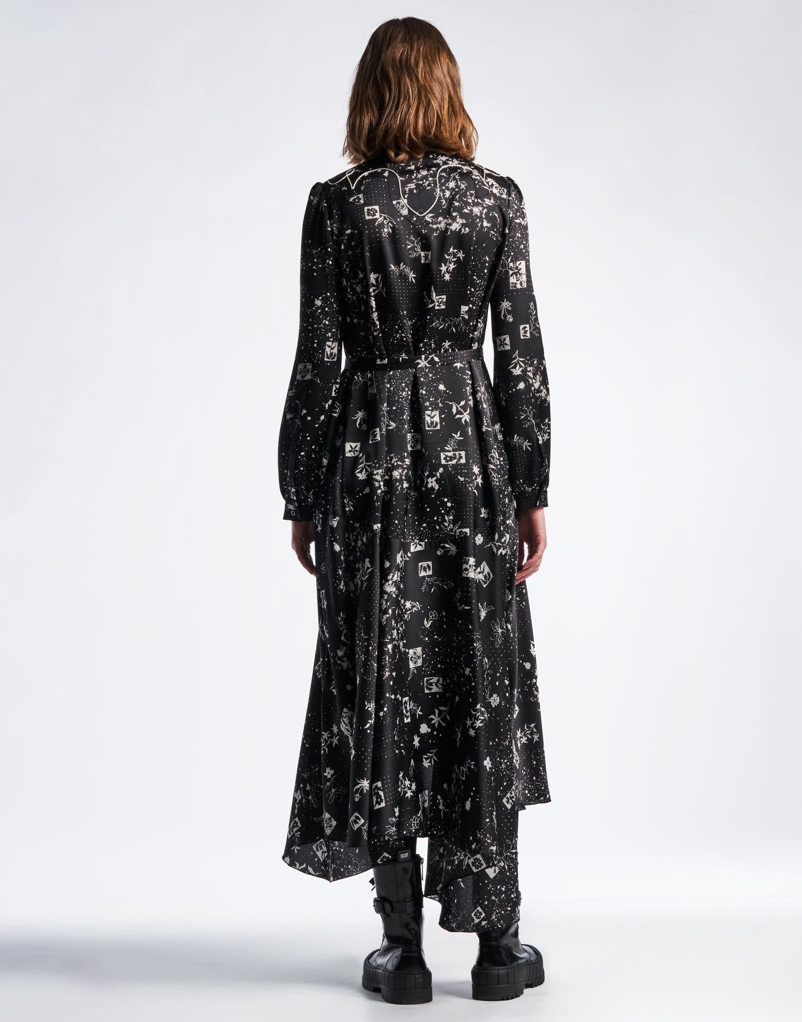 Rückansicht des Kleids COMPELLING: langes schwarzes Hemdkleid aus Funktionssatin mit geometrischem Blumenmuster, elfenbeinfarbenen Akzenten und gerafften Ärmeln.