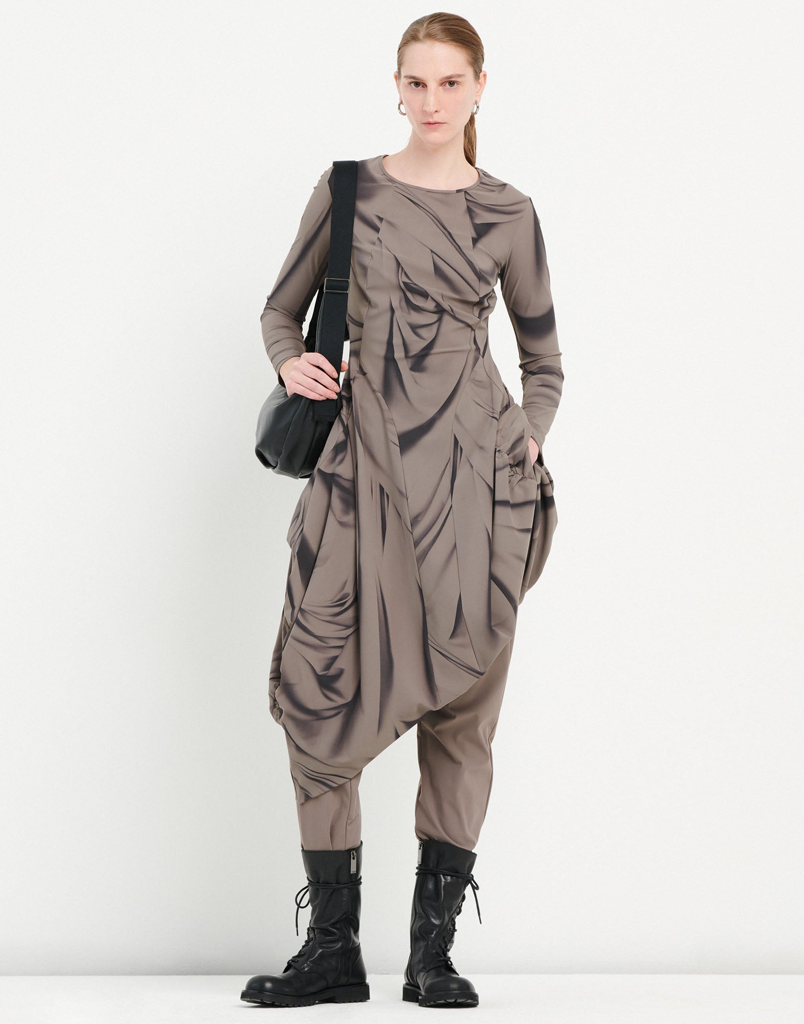 Frontalansicht eines Models, das das AT-LENGTH Kleid trägt. Das Kleid ist taupefarben mit Drapery-Druck, ballonförmig, hat lange Ärmel und seitliche Taschen.