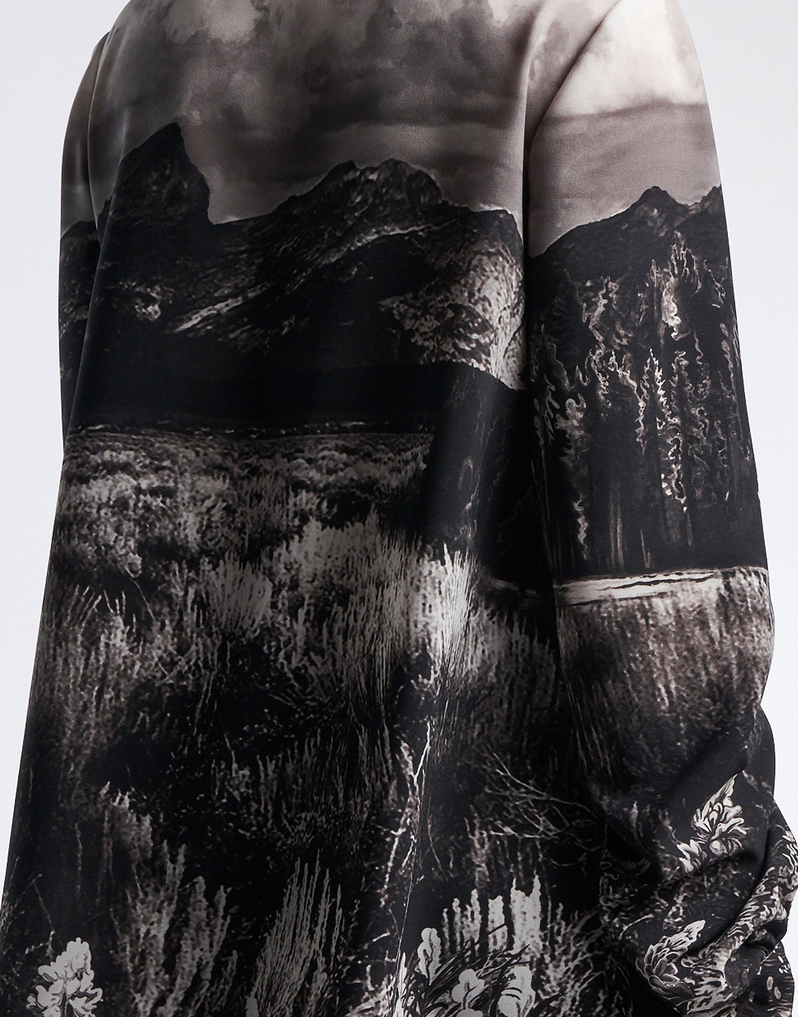 Detail view, side look at the AMAZEMENT blouse in functional crepe with black and white 'Wyoming' print, showing nature motif and fluid fabric.