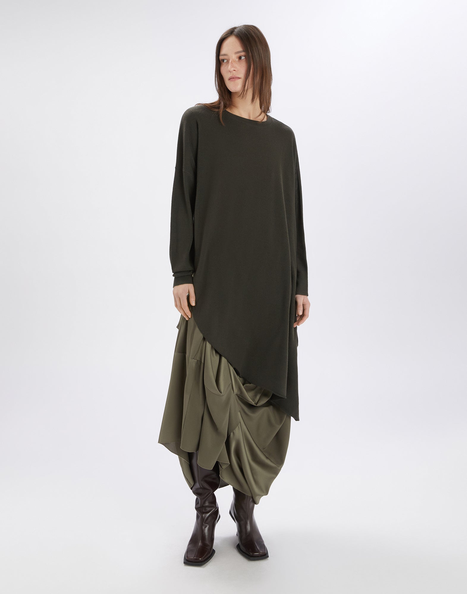 Frontalansicht einer Person, die die ON SET Tunika trägt; das Design ist asymmetrisch geschnitten, aus einer leichten Wollmischung mit langen Ärmeln und rundem Ausschnitt.